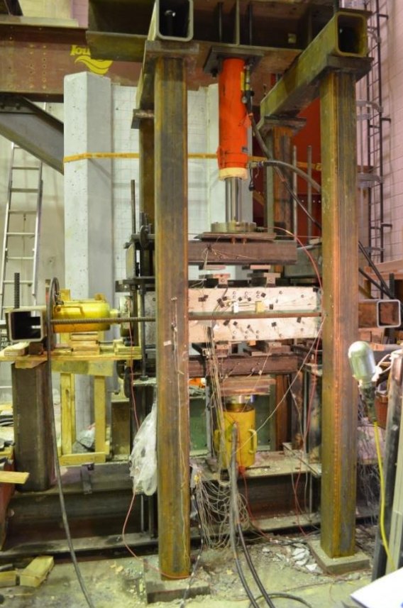 The test frame built in the lab, with a hollow concrete column test unit set between the hydraulic actuators